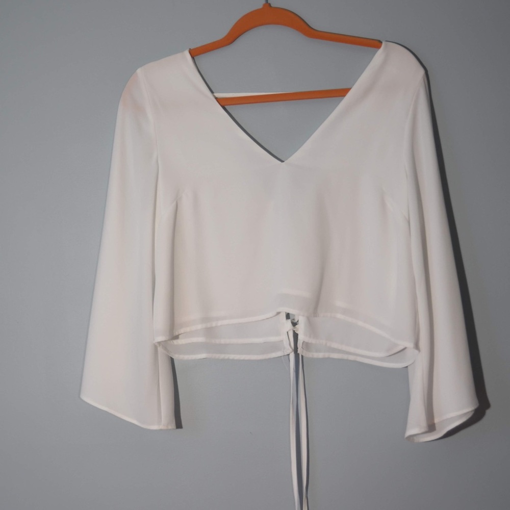 White blouse with trumpet sleeves and lace up back